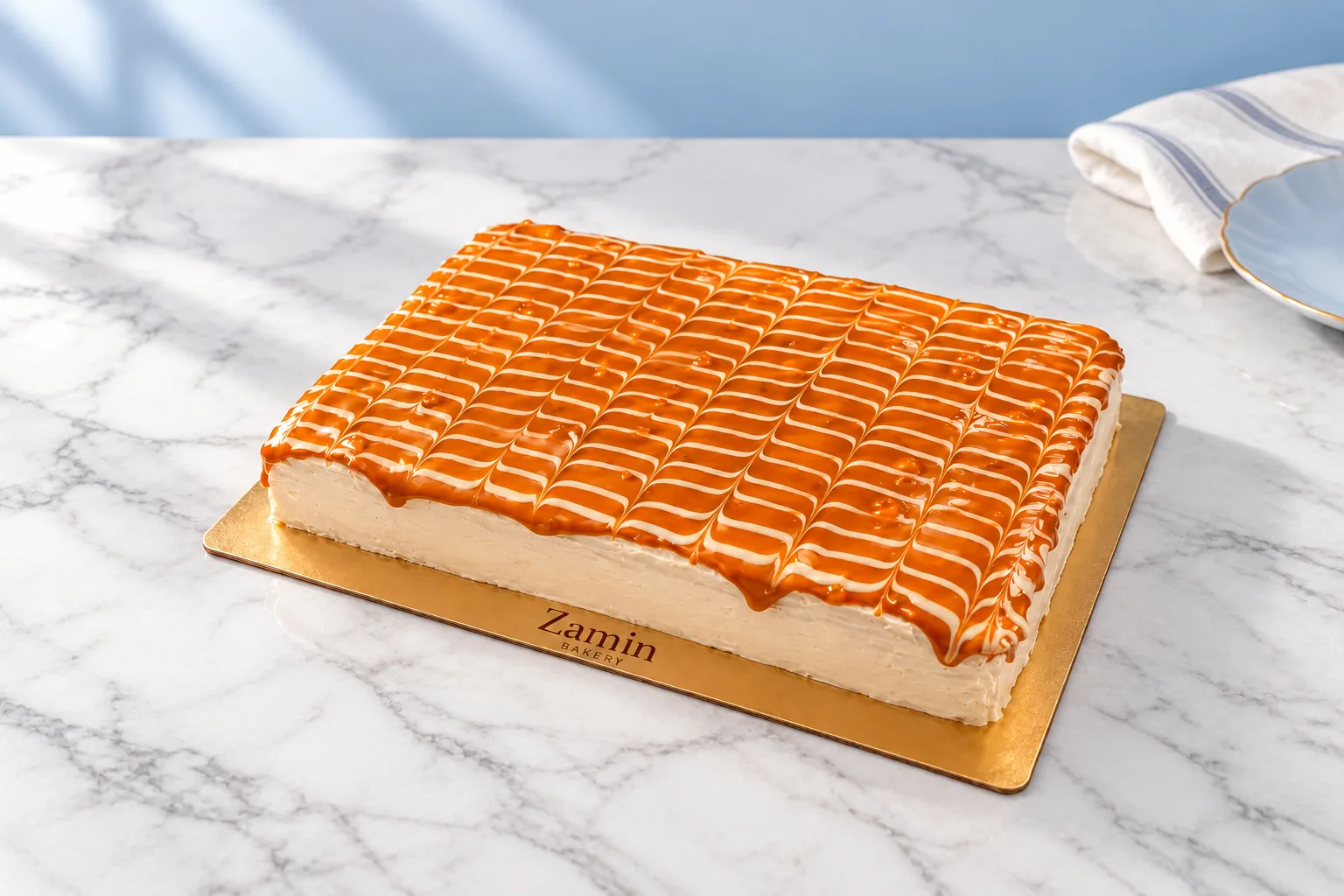 Whole Caramel Cake with a feathered caramel glaze on a branded gold board