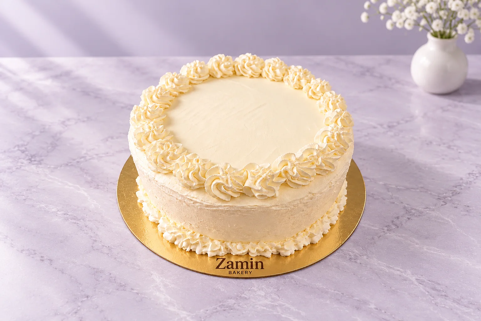 Round cream rosette cake on a Zamin Bakery gold board