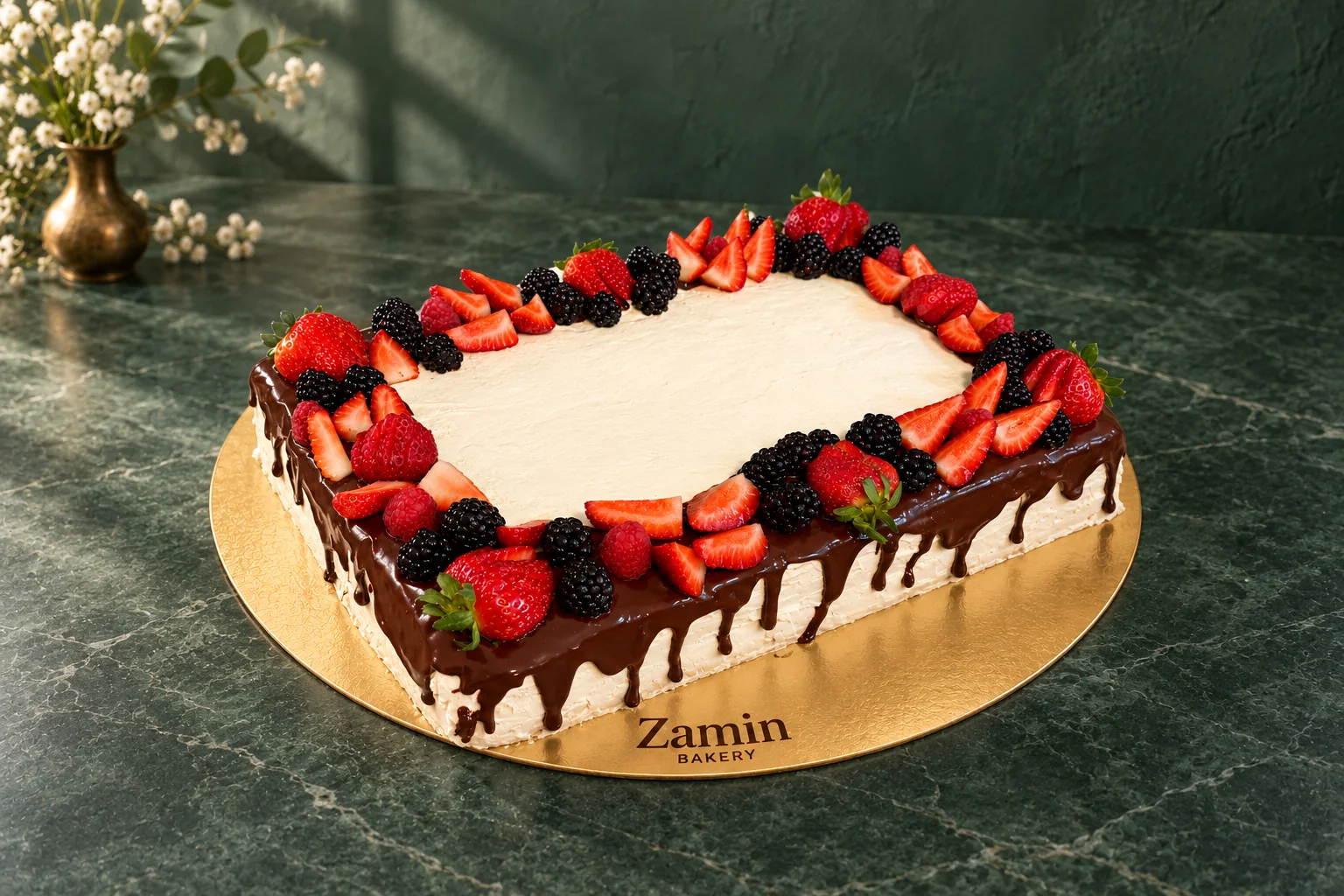 Rectangular cake with a berry border on a Zamin Bakery gold board