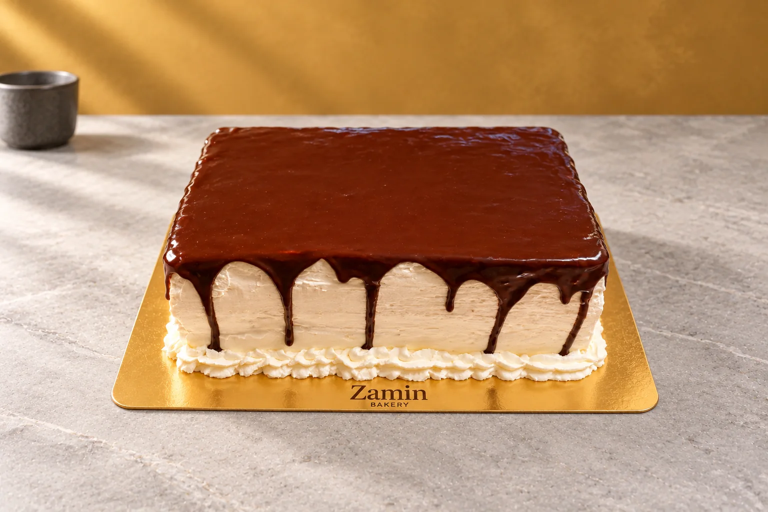 Dark-glazed rectangular cake on a Zamin Bakery gold board