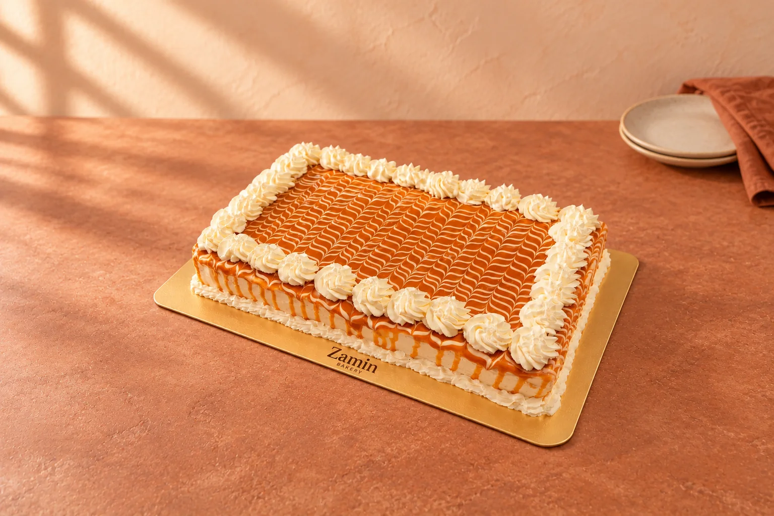 Golden-glazed cake with a rosette border on a Zamin Bakery gold board