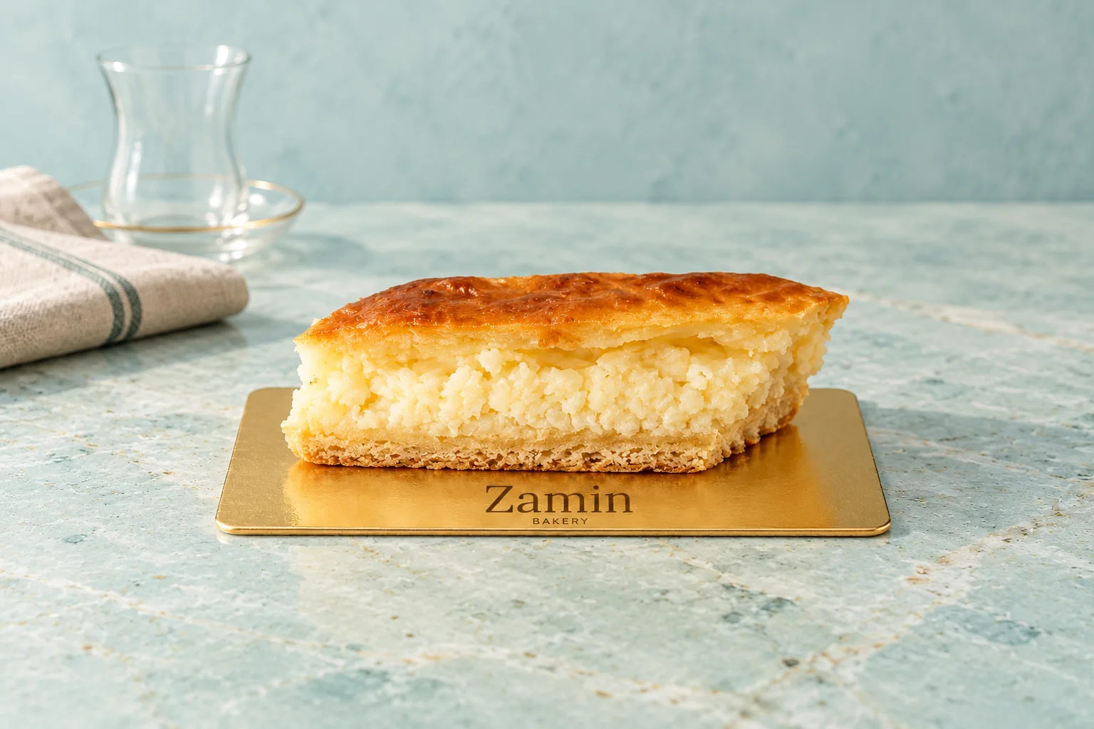 Golden pastry with a pale filling on a Zamin Bakery gold board